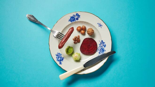 Fleischlos glücklich – so gehts Teller mit Gabel, Messer, Wurst, Nüssen, Rosenkohl und Randen. Die Fakten sind klar: Weniger Fleisch essen ist besser für die Umwelt. Und unsere Gesundheit. Beobachter-Redaktorin Julia Hofer hats ausprobiert – und ist begeistert.