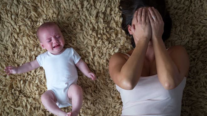 Glückliche Mutter? Schön wärs! Eine Mutter schlägt neben ihrem weinenden Kind die Hände vors Gesicht.
