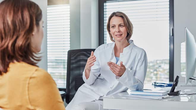 Umstrittene Änderungen per 2022 Eine medizinische Gutachterin spricht mit einer Patientin.