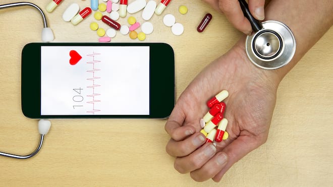 «Viele Gesunde messen fanatisch» Eine Frau hält symbolisch ein Stetoskop auf ihr Handgelenk, um den Puls zu messen.