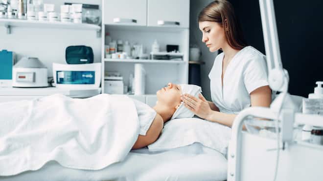 Kosmetikschule trägt dick auf Gesichtsbehandlung bei der Kosmetikerin