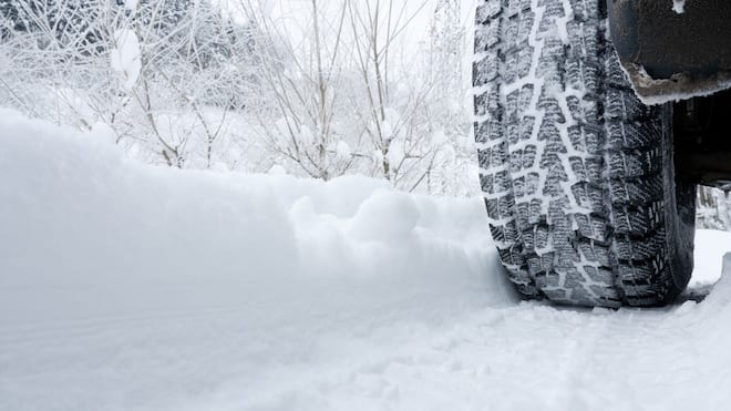 Warum Ganzjahresreifen keine Ganzjahreslösung sind Ein Auto fährt auf einer verschneiten Strasse mit Winterpneus - Es wird wieder Zeit für Winterreifen. Was man dabei beachten muss