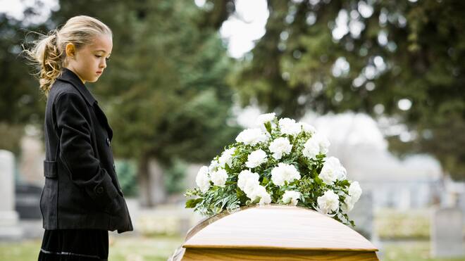 Wieso schaltet sich die Kesb ein? Ein trauerndes Mädchen in schwarz gekleidet steht neben einem Sarg.
