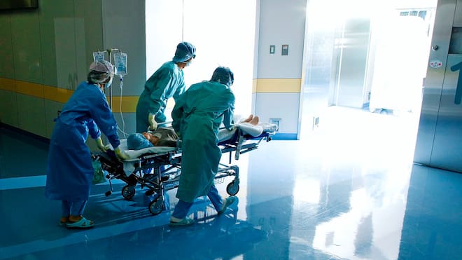 Wenn lieber vertuscht wird Eine Patientin im Bett wird von Spitalpersonal durch einen Gang gestossen