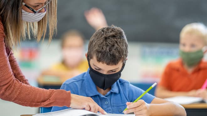 Bundesgericht stützt Maskenpflicht an Schulen Eine Lehrerin erklärt einem Schüler eine Aufgabe, beide tragen eine Maske.