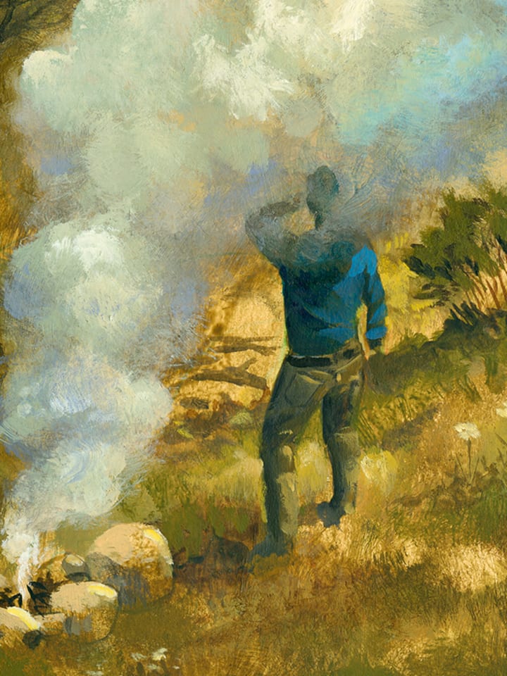 Mann steht neben rauchendem Feuer.