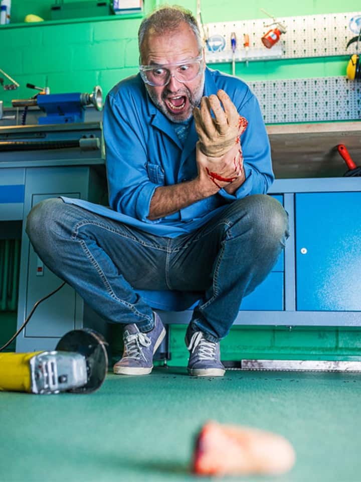 Ein Mann hält sich die Hand, der abgetrennte Finger liegt vor der Kamera.