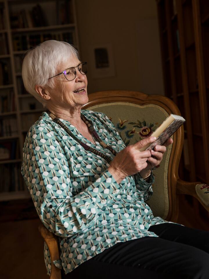 Elisabeth Erb liest auf einem Stuhl in einem ihrer 3000 Märchenbücher. «Das machte mir Mut»: Ein Märchen kann auch eine Lebenshilfe sein, sagt Elisabeth Erb.