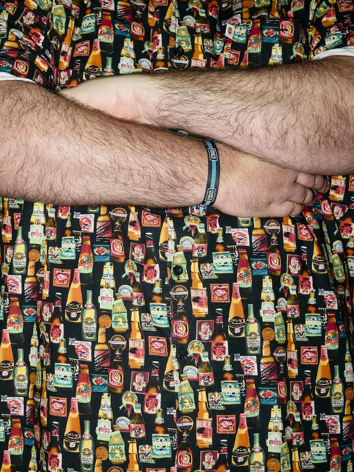 Ein Tag unter Männern – eine Spurensuche Nahaufnahme von Torso mit verschränkten Armen - Was für Männer begegnen uns an einem einzelnen Tag? Eine Reporterin und ein Reporter haben genau hingeschaut – zu Hause, im Internet, an einem Fussballspiel und an einer Männermesse. Und dann kams zur Prügelei