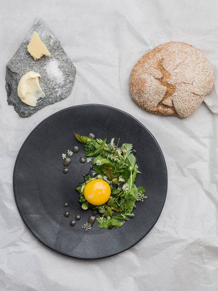 Wildkräutersalat mit Urdinkelbrot, confiertem Eigelb und wildem Lauch