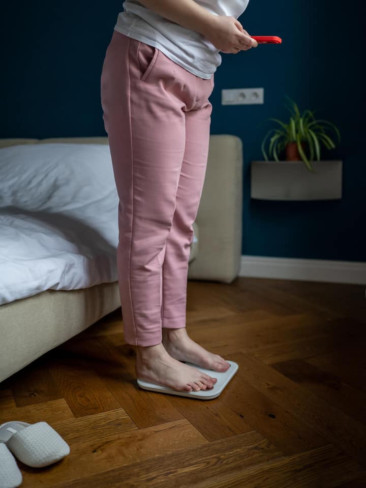 Je weniger man isst, desto stärker wehrt sich der Körper Übergewichtige Frau kontrolliert ihr Gewicht