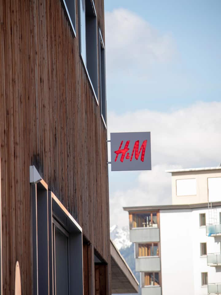 H&H-Schild an einer Hausmauer - Bei T-Shirts gehen die Preise extrem auseinander. Der Beobachter erklärt anhand eines Beispiels von H&M, wieso das so ist – und gibt Tipps für den Einkauf