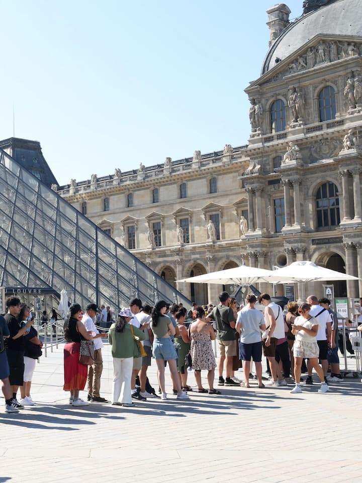 Wie Fake-Websites Schweizer Ferienreisende abzocken Besucher mit Zeitfenster-Ticket 11:00 stehen vor dem Musée du Louvre an.©PHOTOPQR/LE PARISIEN/Delphine Goldsztejn (Staff) ; Paris ; 09/07/2026 MusÈe du Louvre..les tempÈratures vont encore grimper dans les prochains jours. Le week-end et le dÈbu…