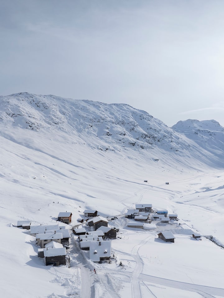 Blick über Juf und das verschneite Averstal - Das Bündner Averstal kämpft gegen Entvölkerung. Als die Dorfbeiz von Juf zum Ferienhaus zu werden droht, greift ein ehemaliger Postautofahrer zu einem rettenden Trick