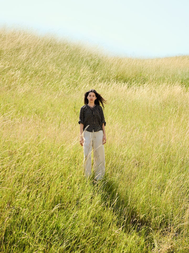 Mahbube Ibrahimi steht auf einer Wiese - sie flüchtete allein in die Schweiz und startete das Projekt «Wild Flower». Die Online-Schule trotzt dem Bildungsverbot der Taliban und gibt 270 Afghaninnen Hoffnung