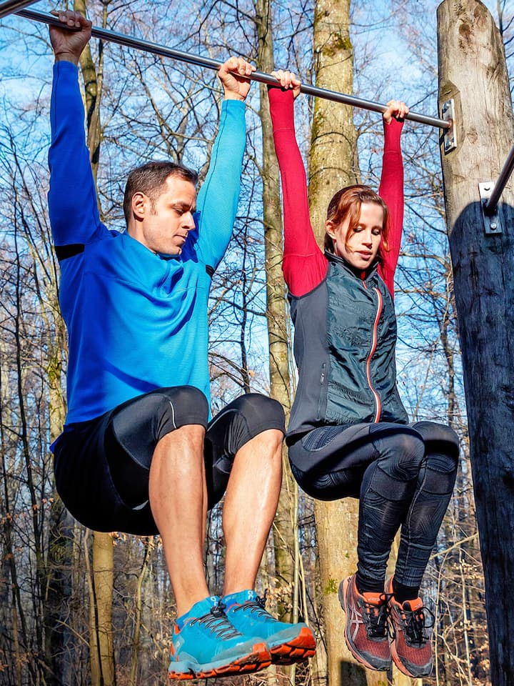 Jasmine Helbling und Marton Gintner machen Klimmzüge auf dem Vitaparcours