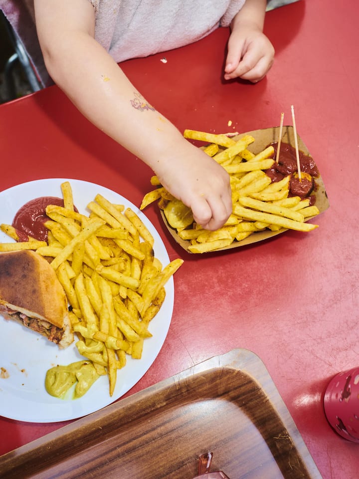 So tickt die Schweiz Kind ist Pommes frites, man sieht nur die Hände - Was macht die Schweiz aus? Natur, Sicherheit, Demokratie. Und wie ticken die Menschen hier? Sie sind bodenständig und fleissig – und wünschen sich insgeheim, dass alles so bleibt, wie es ist