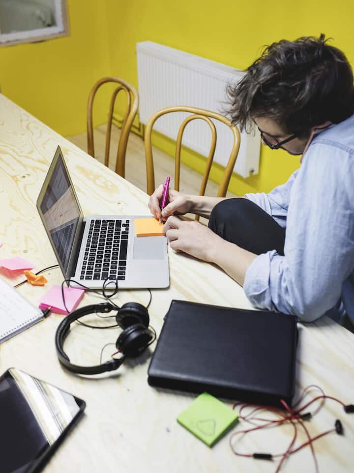 Mann vor Laptop macht sich Notizen - Während des Sommers bleiben viele Dienste und Abos ungenutzt. Vor dem Herbst ist darum der richtige Zeitpunkt, um konsequent auszumisten. Eine Anleitung in vier Schritten