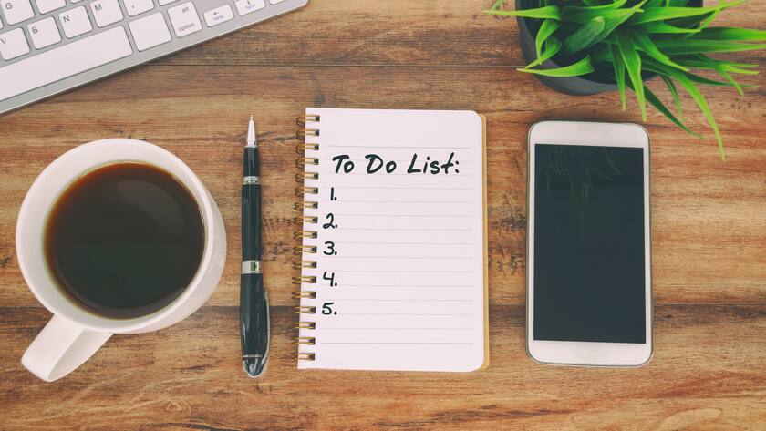 So packen Sie es in fünf Schritten an! Eine Liste mit fünf aufgezählten Punkten liegt auf einem Schreibtisch neben einer Tasse Kaffee, einem Handy und einem Laptop. Wer die Steuererklärung ausfüllt, sollte systematisch vorgehen. So geht es in 5 Schritten.