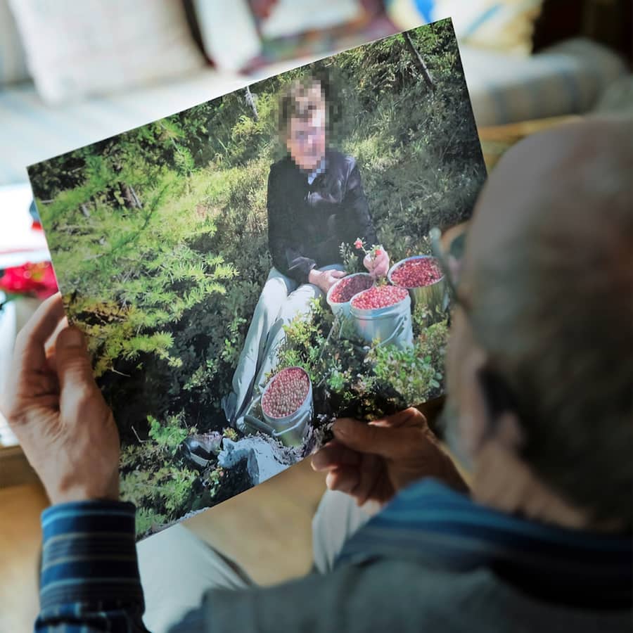 Walter Derungs beim Betrachten von Bildern seiner verstorbenen Frau.