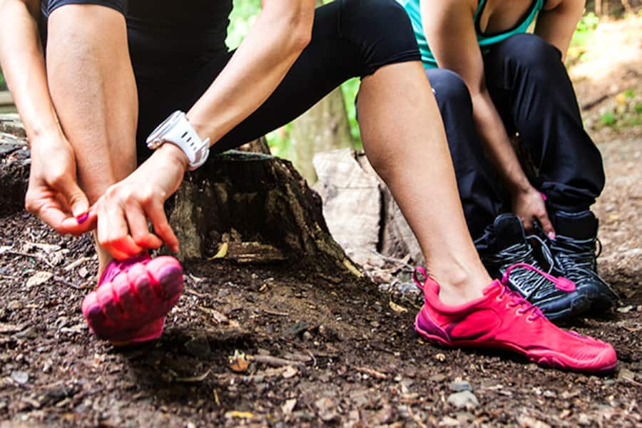 Eine Frau schnürt ihre Barfussschuhe.