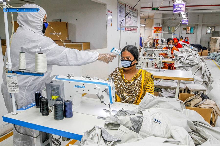 Eine Arbeiterin in Bangladesch wird getestet, ob sie Fieber hat