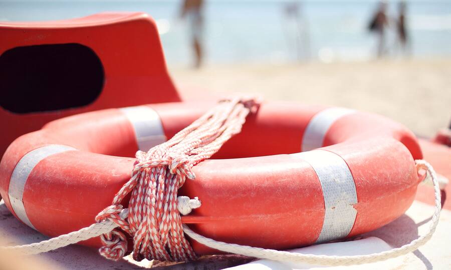 rot-weisser Rettungsring liegt auf einem Rettungsboot am Meer