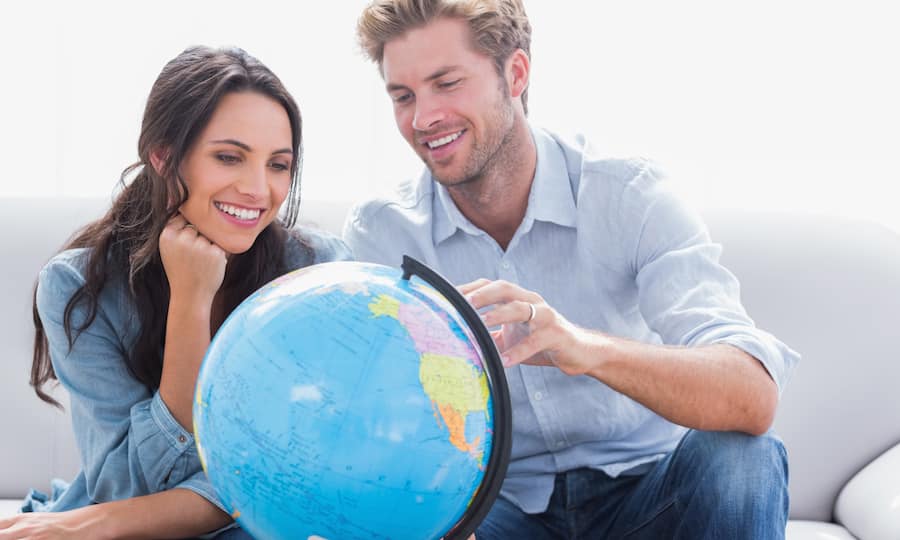 Mann und Frau betrachten Globus vor ihnen