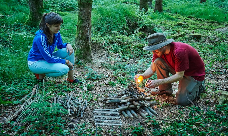 Zwei Waldcamper entzünden ein Pagodenfeuer