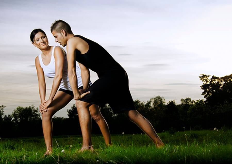 Ein junges Paar macht ein paar Dehnübungen nach dem Joggen.