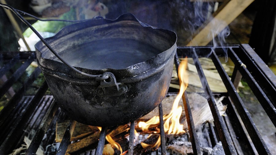 Ein Topf steht auf einem Rost über einem Feuer