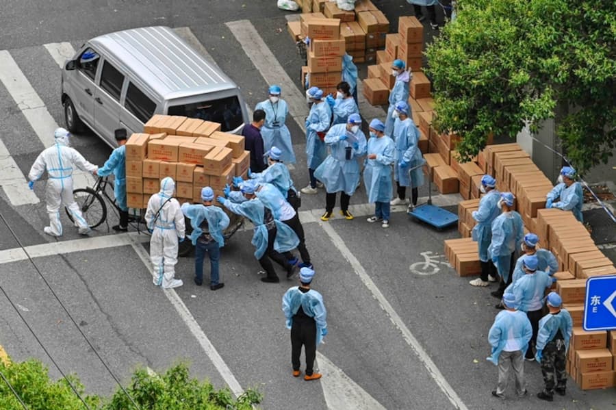 Lockdown in Schanghai: Arbeiter in Schutzkleidung fahren Fresspäckli in die Quartiere.