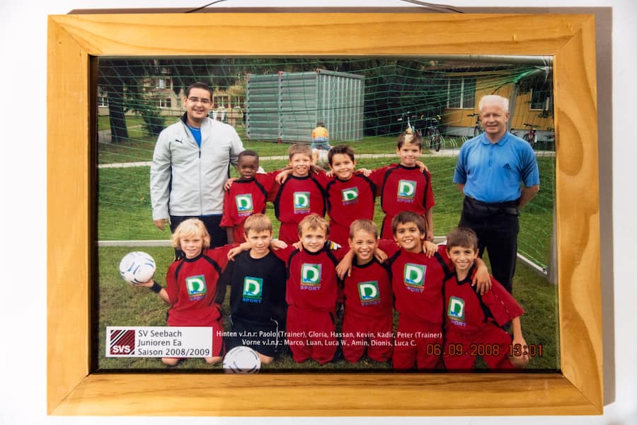 Ein Teambild vom Jahre 2008 mit Paolo Vitale, hintere Reihe links, und neben ihm Gloria Antonio sowie Luan Läubli, vordere Reihe zweiter von links, im Klubhaus des SV Seebach beim Sportplatz Buchwiesen in Seebach, in Zuerich, am Donnerstag, 22. August 2022. (Foto: Dominic Steinmann)