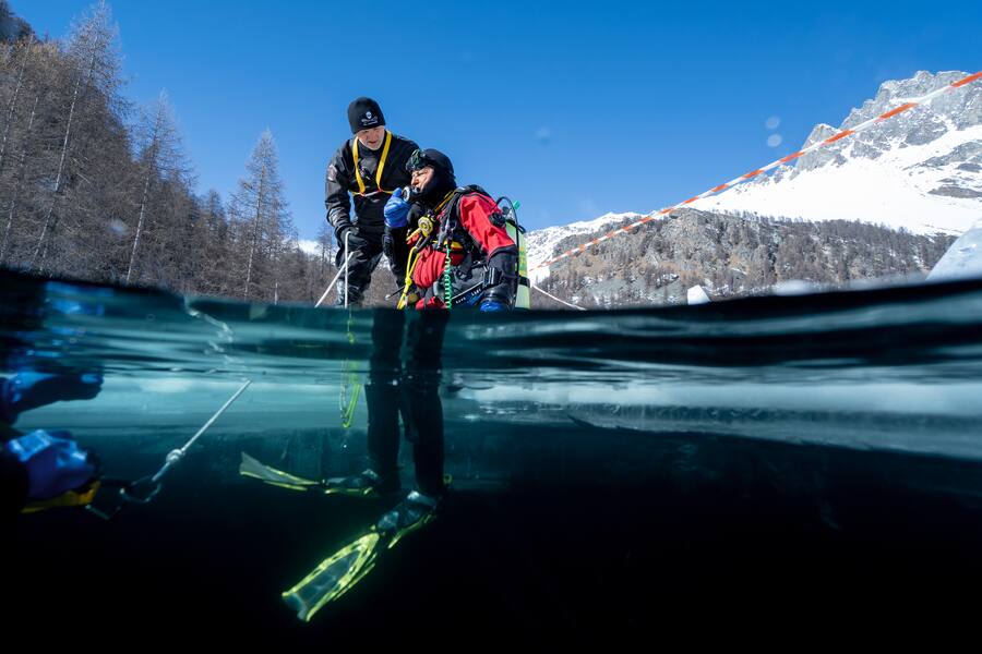 Eistaucher macht sich auf den Sprung in den vereisten See bereit. «Ich bin nicht mehr sicher, ob das eine gute Idee war»: Der Moment, in dem man sich fallen lassen muss. Ein Sprung unters Eis löst bei vielen Panik aus. Doch wer die Angst besiegt, wird mit einem überirdischen Erlebnis belohnt.