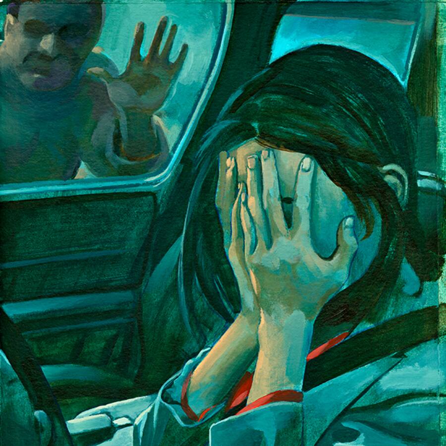 Frau sitzt weinend im Auto