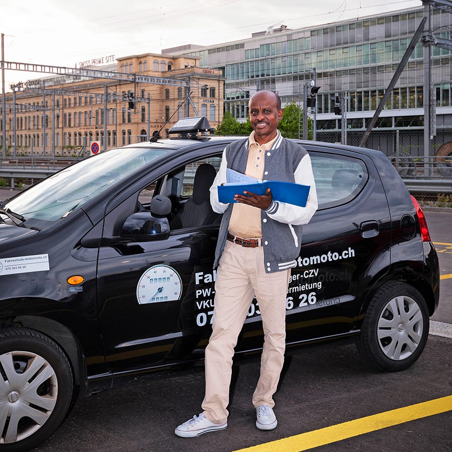 Mann steht vor Auto.