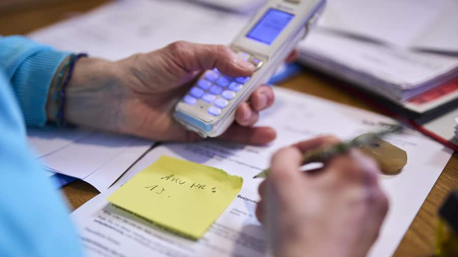 Hand mit Taschenrechner - Weil sie eine Witwenrente bekommt, sollte Eva Müller (Name geändert) keine 13. AHV-Rente erhalten. Doch sie gab nicht klein bei. Rund 10’000 Personen in der Schweiz könnten ebenfalls betroffen sein
